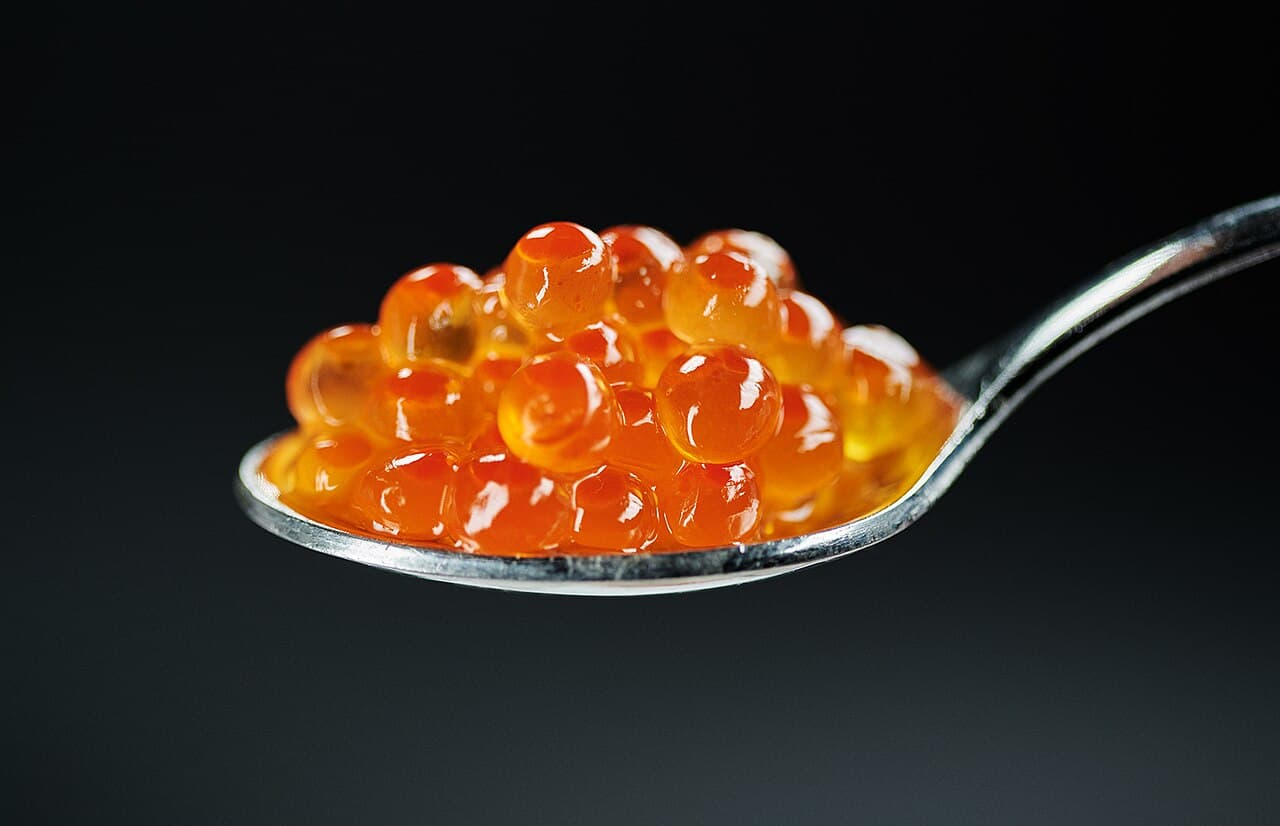 Salmon caviar on a spoon, the ingredient behind Salmon roe